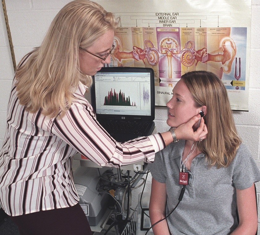 Professor demonstrating hearing research to student