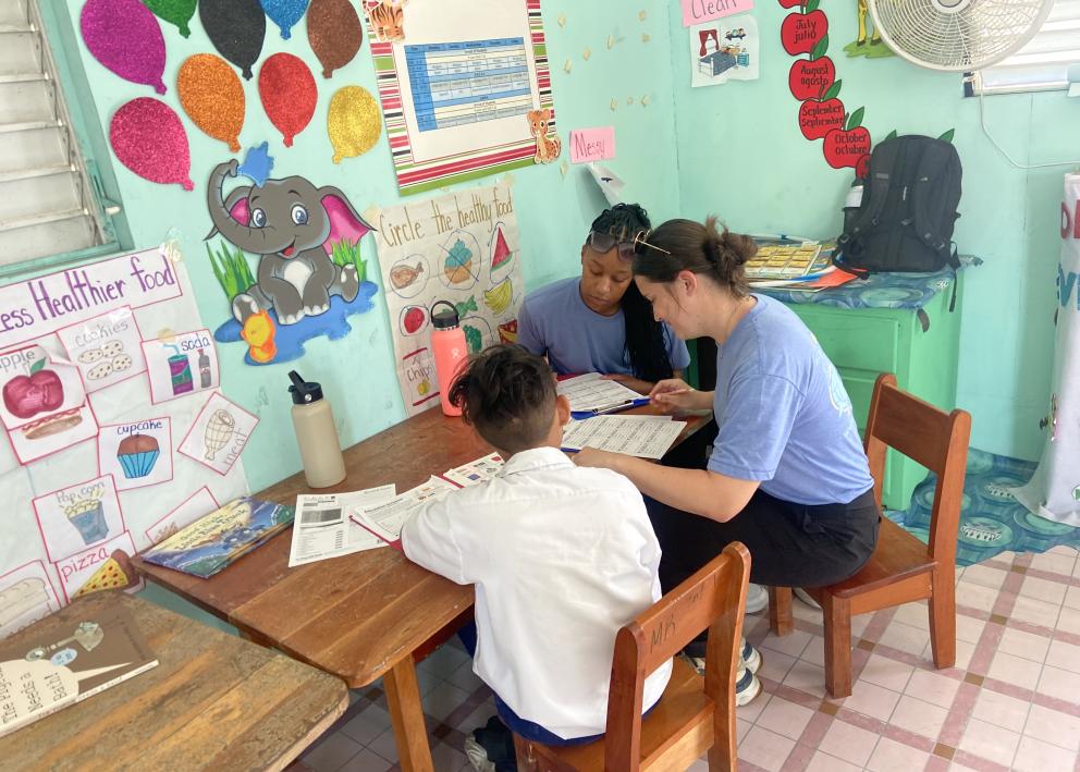 Three people sitting at a table looking at sheets of paper
