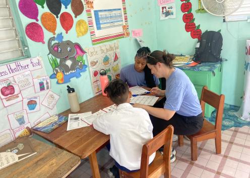 Three people sitting at a table looking at sheets of paper
